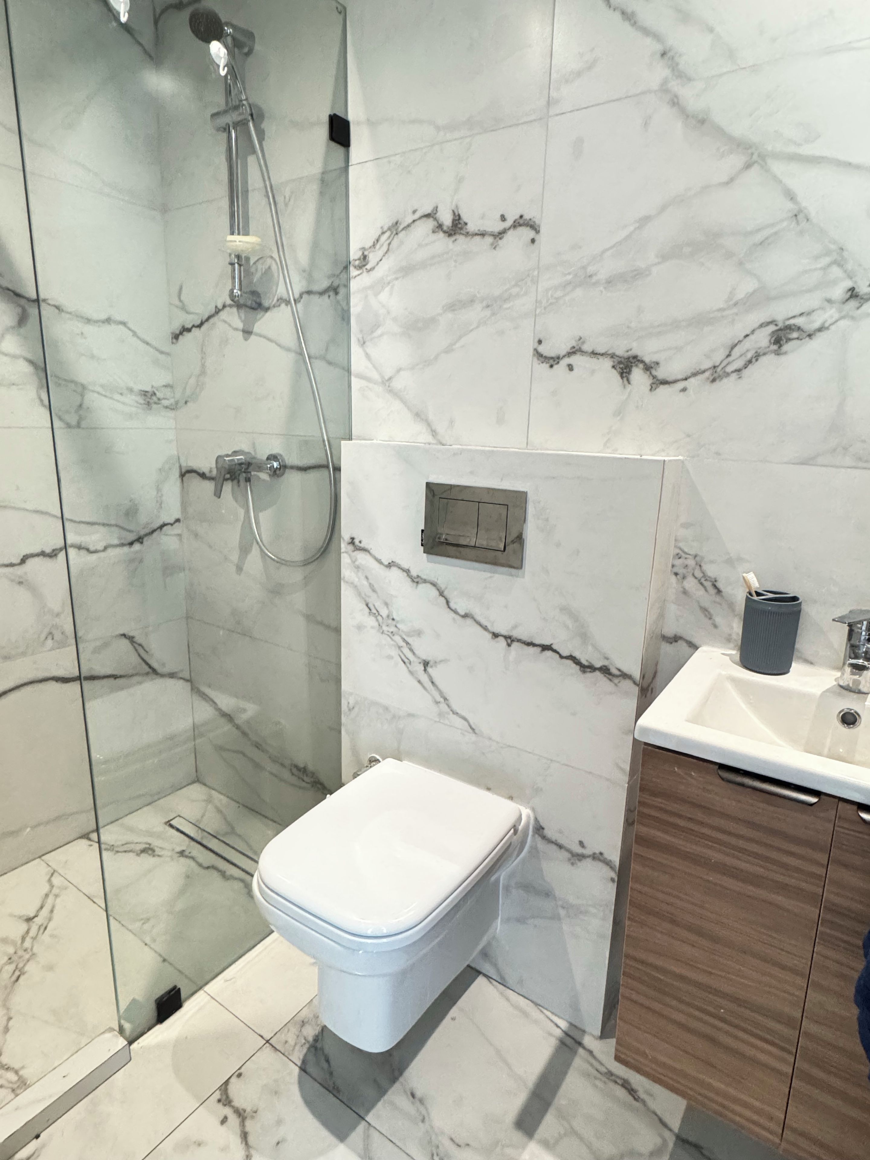 Une salle de bain avec des toilettes, une douche et un lavabo.