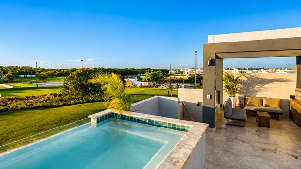 A rooftop pool with a view of a golf course and residential buildings. - Luxury Rooftop with Views of Cana: Pool, Sunset, Golf (Punta Cana)