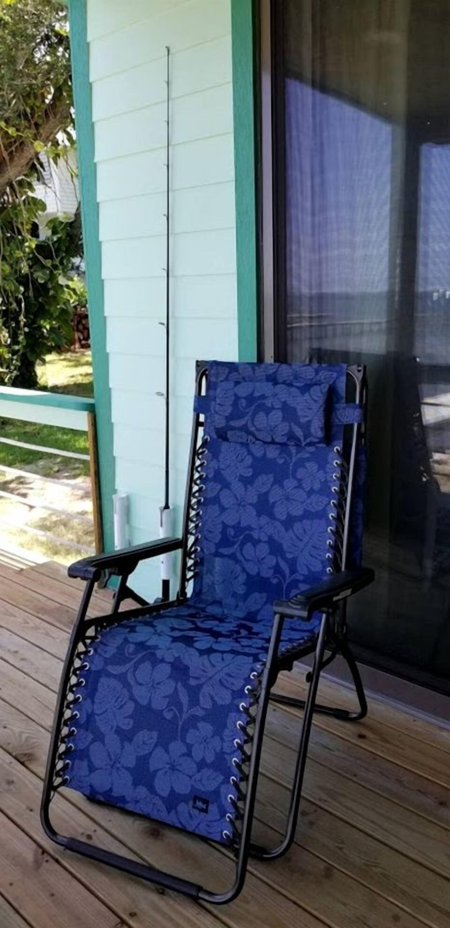 A blue patterned chair on a wooden deck.