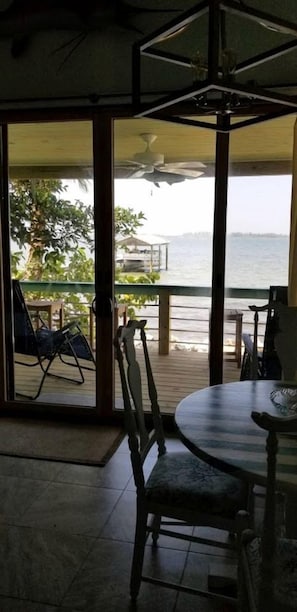 A room with a view of the sea, a table, and chairs. - Beautiful Waterfront Cottage for a Peaceful Romantic Escape in Micco, Florida (Micco)