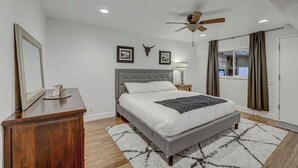 A bedroom with a bed, a ceiling fan, a nightstand, a lamp, and a window with curtains. - Superb 4-bedroom condo with AC in quaint Brian Head steps from Giant Steps Lodge (Brian Head)