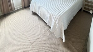 A hotel room with a bed, a nightstand, a lamp, a ceiling fan, and a view of the outside. - Newly furnished getaway, minutes from Ole Miss! (Oxford)