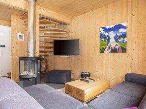 Ein modernes Wohnzimmer mit Kamin, Flachbildfernseher und einem Gemälde an der Wand.