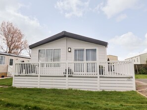 A single-story mobile home with a front deck and a small porch. - Rosella 38 (Morecambe)