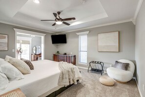 A bedroom with a bed, a ceiling fan, a TV, a dresser, a chair, and a window. - Comfortable Pool Home with Spacious Game Room Escape in Decatur, Texas (Decatur)