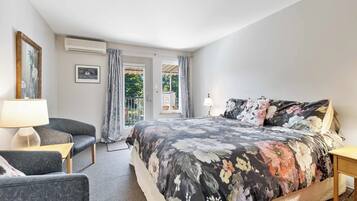 Une chambre à coucher avec un lit, une chaise, une lampe et une fenêtre avec des rideaux.
