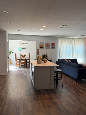 A modern living space with a kitchen, dining area, and a sofa. - Spacious 4-bedroom house in lovely Denton TX (Denton)