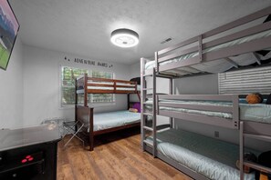 A bunk bed room with a desk and a window. - Quiet 4BR w/Hot Tub*Game Room*Chalet Village*Ober (Gatlinburg)