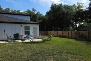 A residential backyard with a patio, a hammock, and a wooden fence. - New Massage Chair / Clean / 3 BR / RV Pwr / Foley / Yard 124 (Foley)