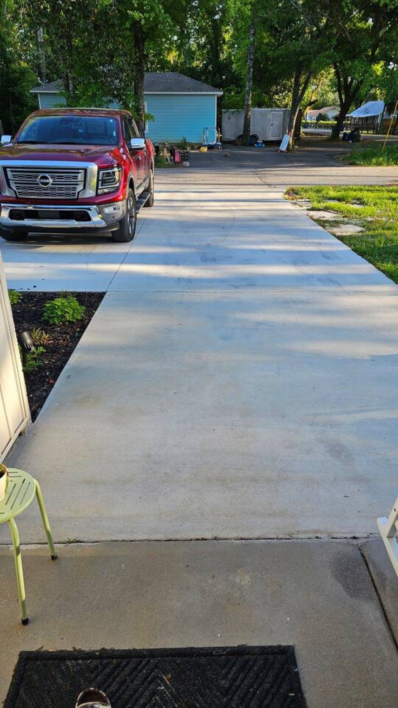 A residential driveway with a red truck parked on the left.