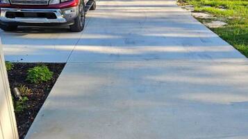 A residential driveway with a red truck parked on the left.