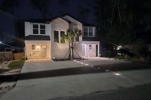 A two-story house with a garage, a driveway, and a well-lit entrance. - New Massage Chair / Clean / 3 BR / RV Pwr / Foley / Yard 124 (Foley)