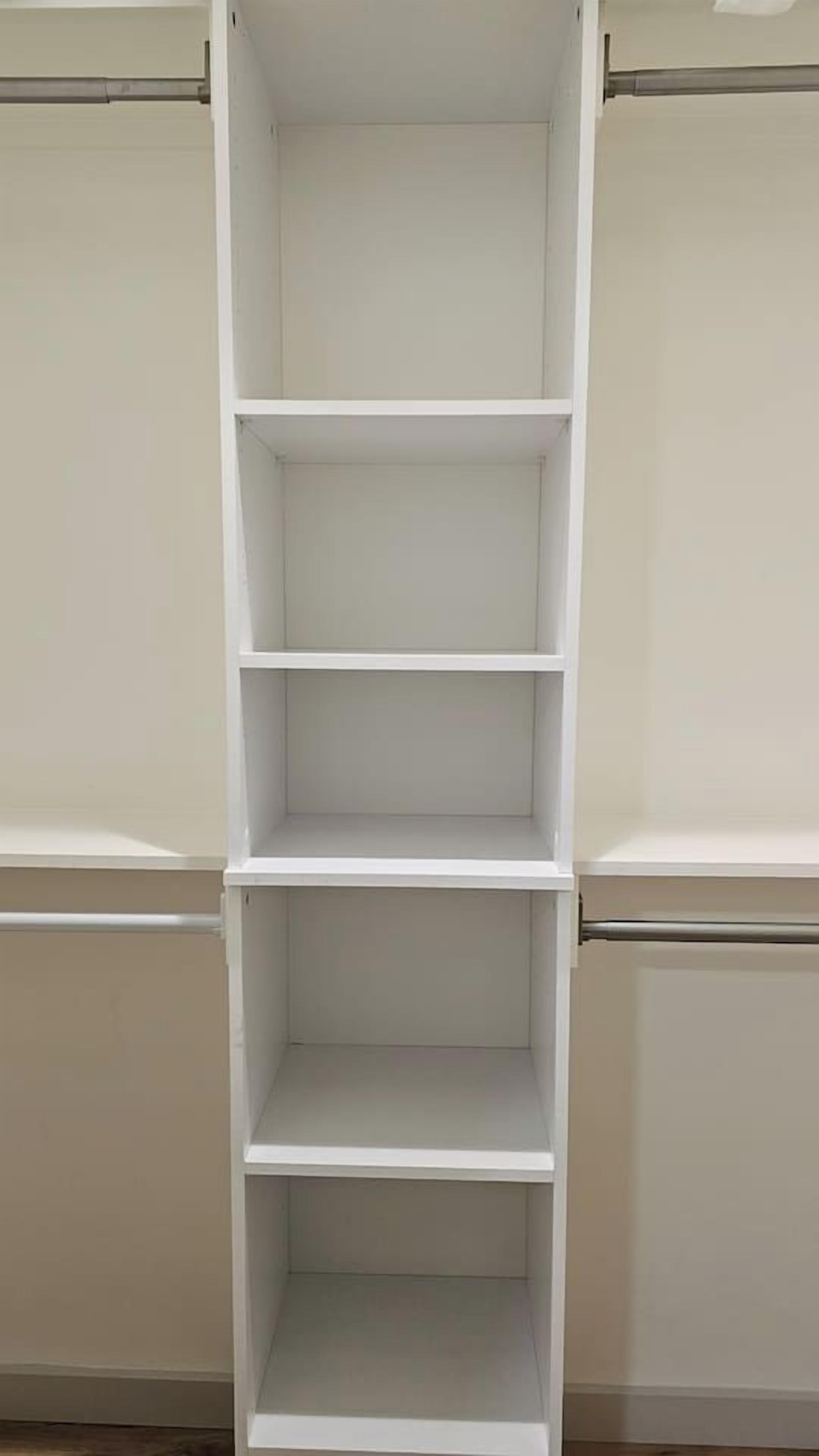 Un estante blanco con cuatro repisas, probablemente utilizado para guardar objetos.