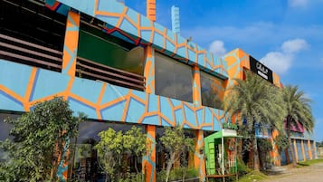 A building with a colorful geometric facade, a sign for 'Collection,' and a green structure labeled 'Quick Charge.'