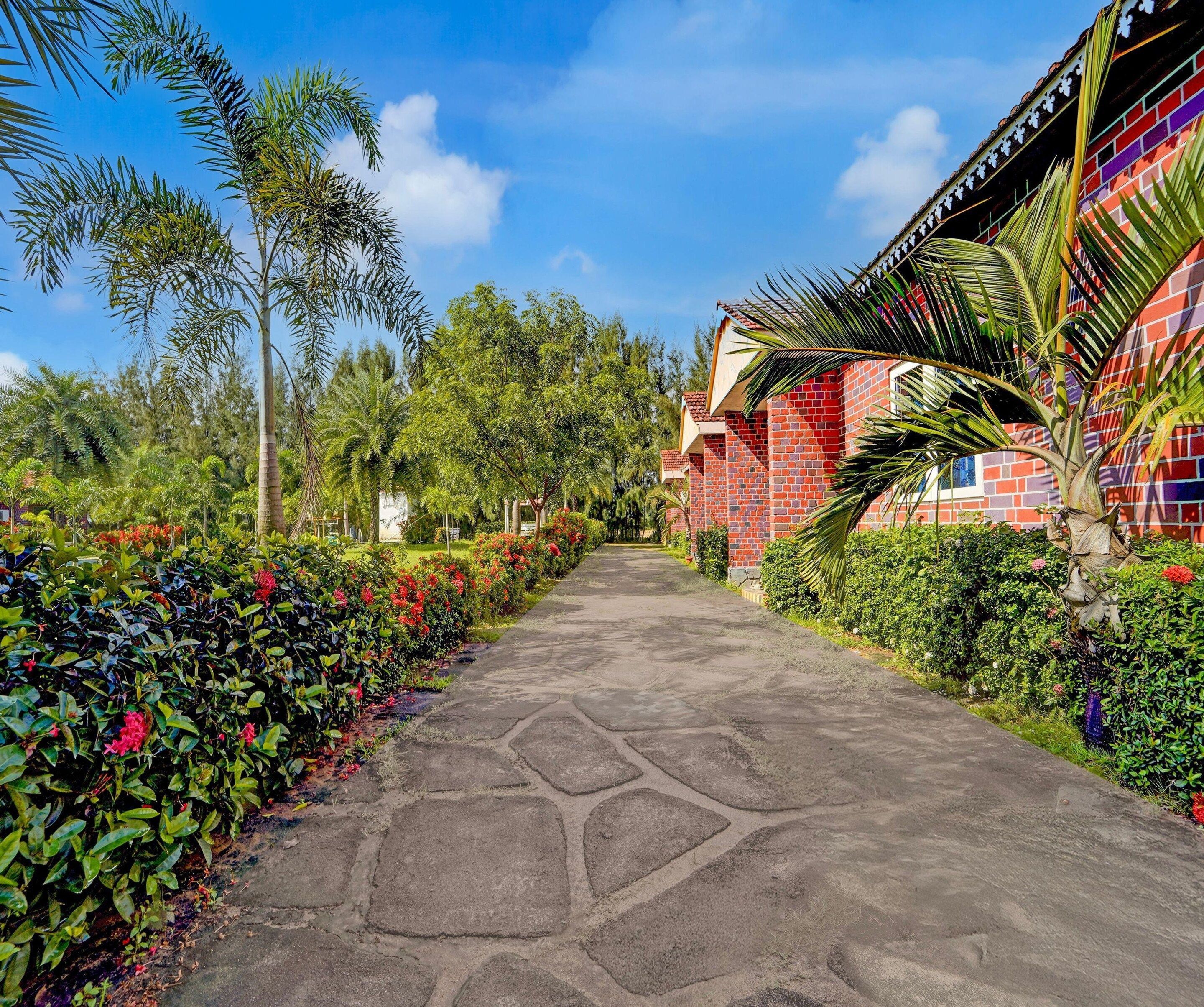A pathway leading to a building with a red brick facade and a tiled roof.