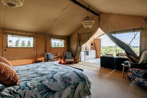 A tented accommodation with a bed, seating area, and a view of the outdoors. - Beautiful Safari Tent on a Gorgeous Vineyard near Hastings, North Island (Hastings)