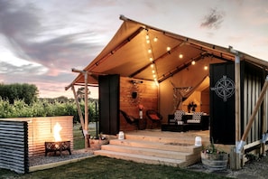 A cozy outdoor tent with a fire pit, seating area, and a compass. - Beautiful Safari Tent on a Gorgeous Vineyard near Hastings, North Island (Hastings)