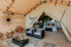 A tented accommodation with a dining area, a bed, and a bathroom. - Beautiful Safari Tent on a Gorgeous Vineyard near Hastings, North Island (Hastings)