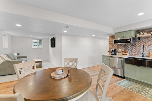 A modern apartment with a dining area, kitchen, and living space.