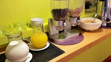 Una barra de desayuno con cafetera, licuadora y jarra de jugo de naranja.