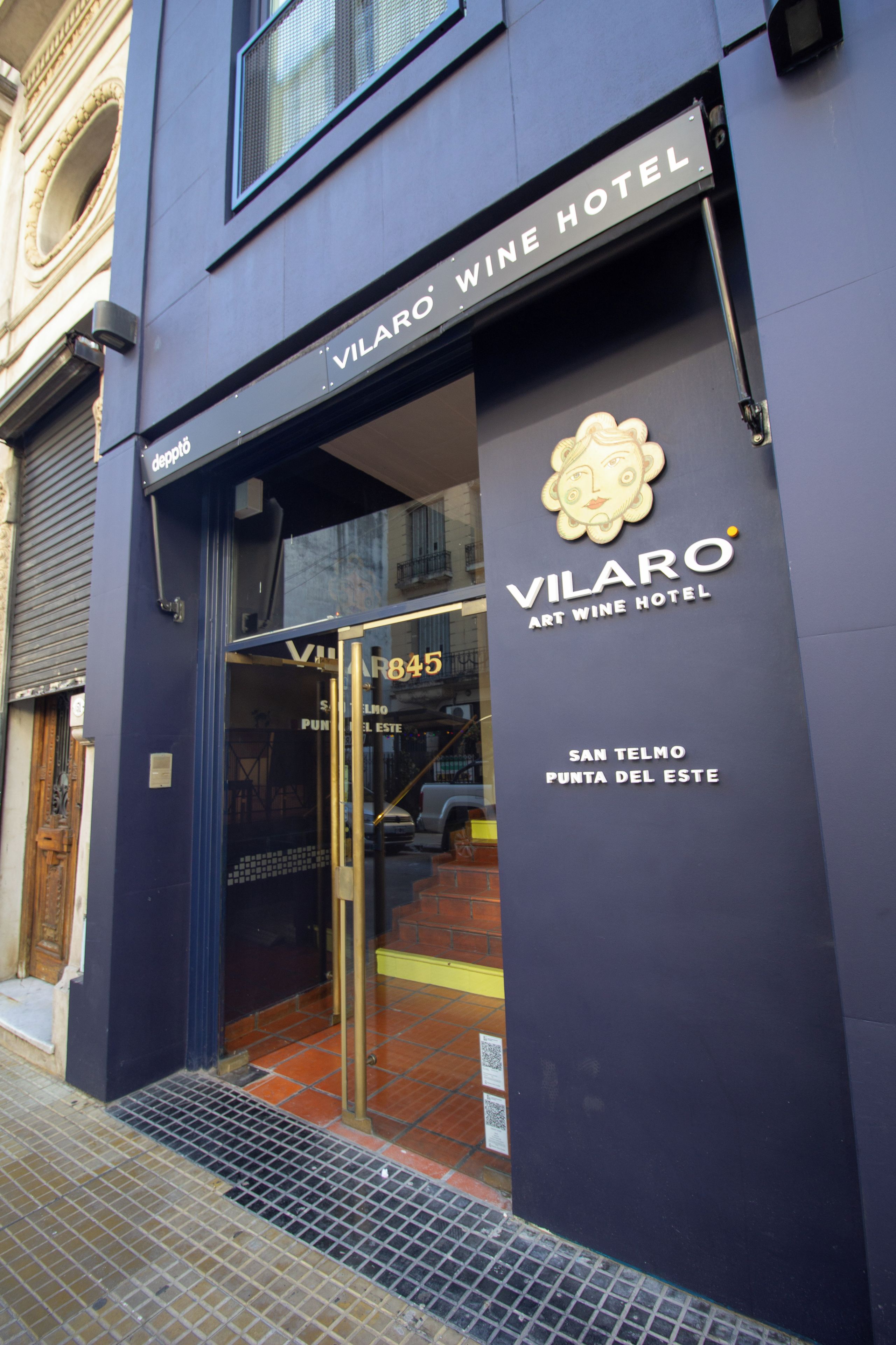 The entrance to Vilaro Art Wine Hotel with a glass door and a sign above the door.
