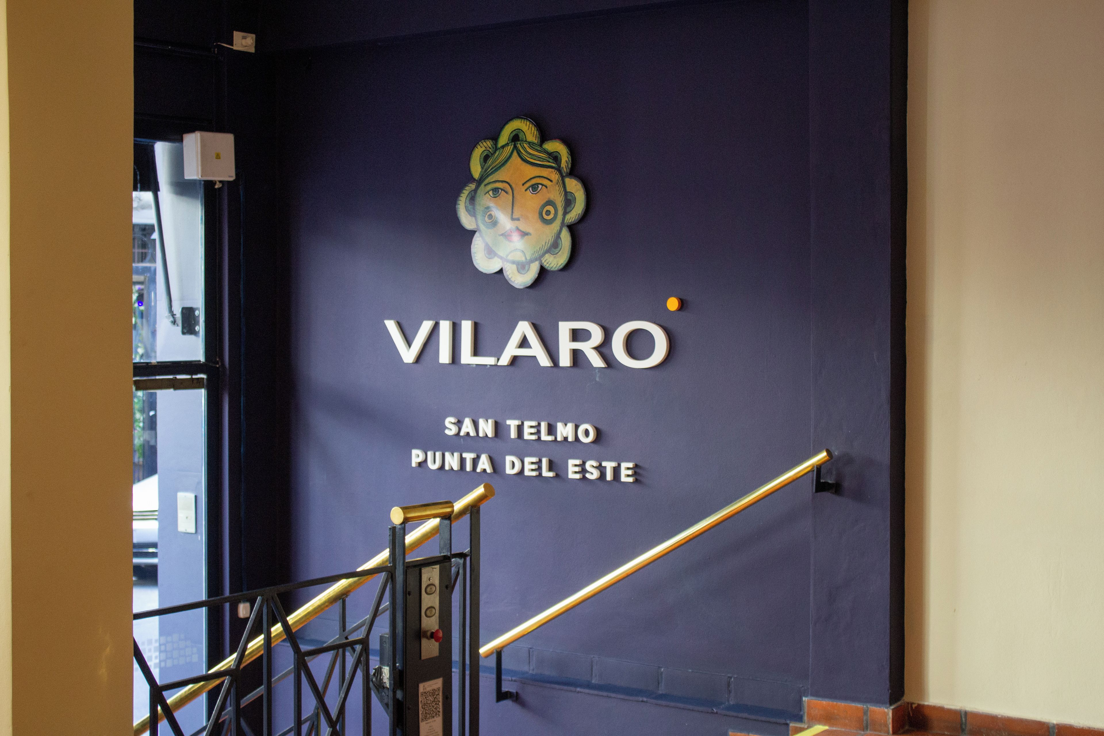 Hotellissa tai muussa toimipaikassa oleva seinä, jossa on teksti ”VILARO” ja osoite ”SAN TELMO PUNTA DEL ESTE”.