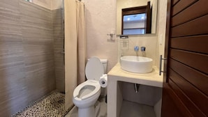 Ein Badezimmer mit Dusche, Toilette und Waschbecken.