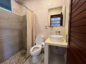 A bathroom with a shower, toilet, and sink. - Casa Parota (Ixtapa Zihuatanejo)