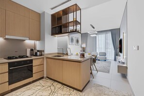 A modern kitchen with a central island, built-in oven, and a dining area with a table and chairs. - Elegant 2BR at VidaDubai Mall Prime Downtown Location (Dubai)