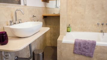 A bathroom with a white sink, a bathtub, and a toilet.