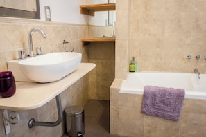A bathroom with a white sink, a bathtub, and a toilet.