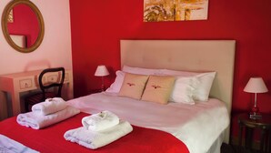 A hotel room with a bed, two bedside tables, a chair, a mirror, and a painting on the wall. - Lovely 2-bedroom bed & breakfast with AC in Buenos Aires (Buenos Aires)