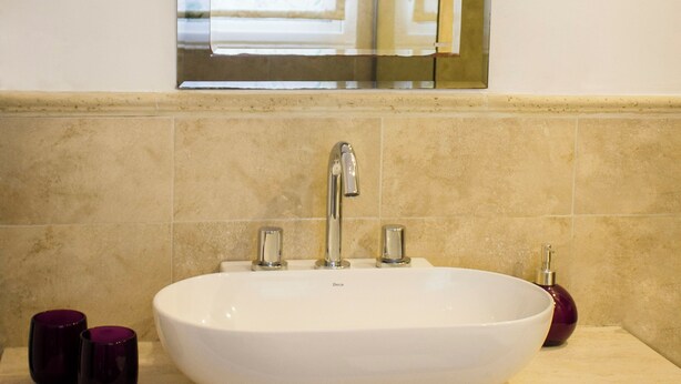 A bathroom with a white sink, a mirror above it, and a window with floral curtains. - Lovely 2-bedroom bed & breakfast with AC in Buenos Aires (Buenos Aires)