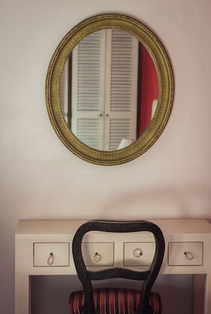A vanity with a mirror and a chair.