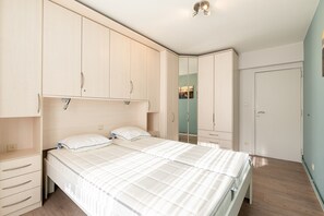 A bedroom with a bed, bedside tables, a wardrobe, and a mirror. - Apartment in Blankenberge With Sea Views (Blankenberge)