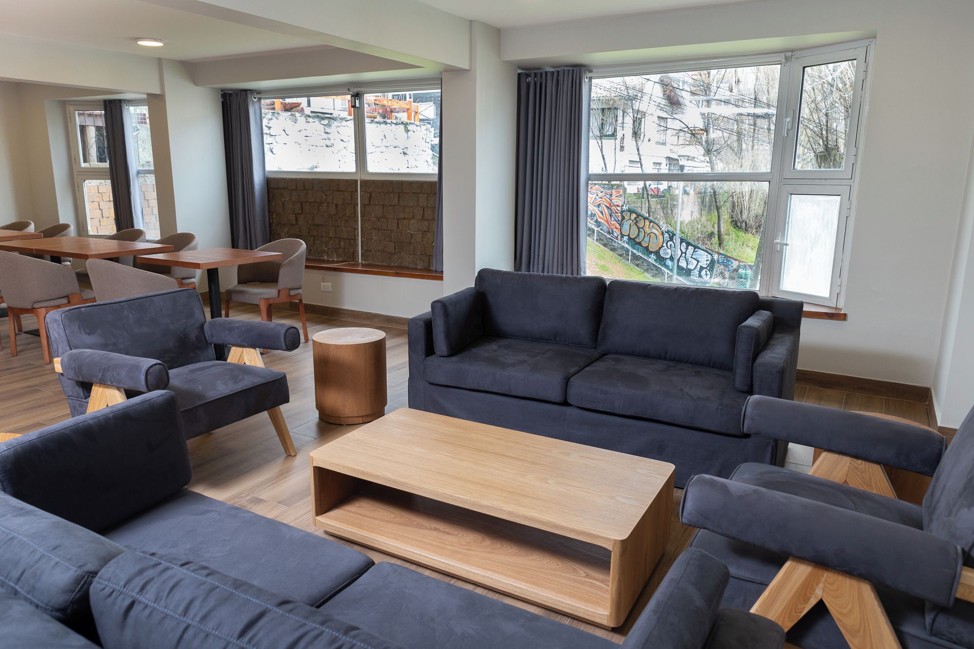 Ein modernes Wohnzimmer mit einer Sofagarnitur, einem Couchtisch und einem Essbereich mit Stühlen und einem Tisch.