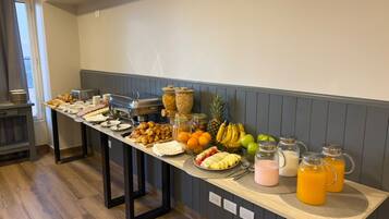 A buffet table with various food items and beverages.