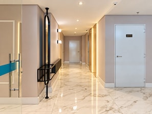 A hotel corridor with a marble floor, a bench, and a door with a service sign. - Ap Blue Garden 800mt da Praia - Itapema/sc (Itapema)