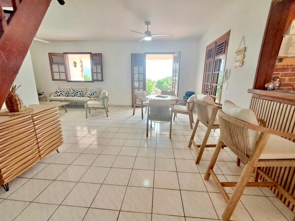Un espacio habitable amplio con un sofá, sillas, una mesa de comedor y un mueble de madera.
