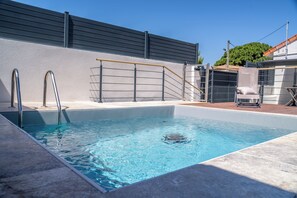 En swimmingpool med gelændinger, en stige og en stol.