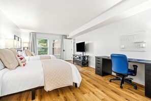 Ein Hotelzimmer mit Bett, Schreibtisch, Stuhl, Fernseher und einer Wandtafel.