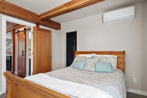 Ein Schlafzimmer mit einem hölzernen Bett, einem Kleiderschrank und einer Klimaanlage.
