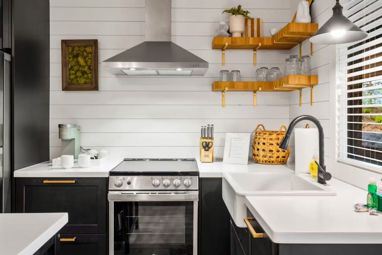 A modern kitchen with a stove, oven, and white countertops.