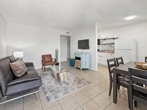 A modern apartment with a living room, dining area, and kitchen.