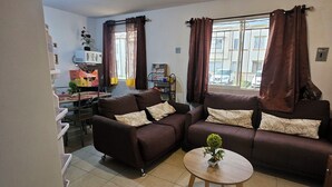 A living room with two sofas, a coffee table, and a window with curtains. - Cozy Ground-Floor Apartment Near U Mondragón, Industrial Area (Real Solare)