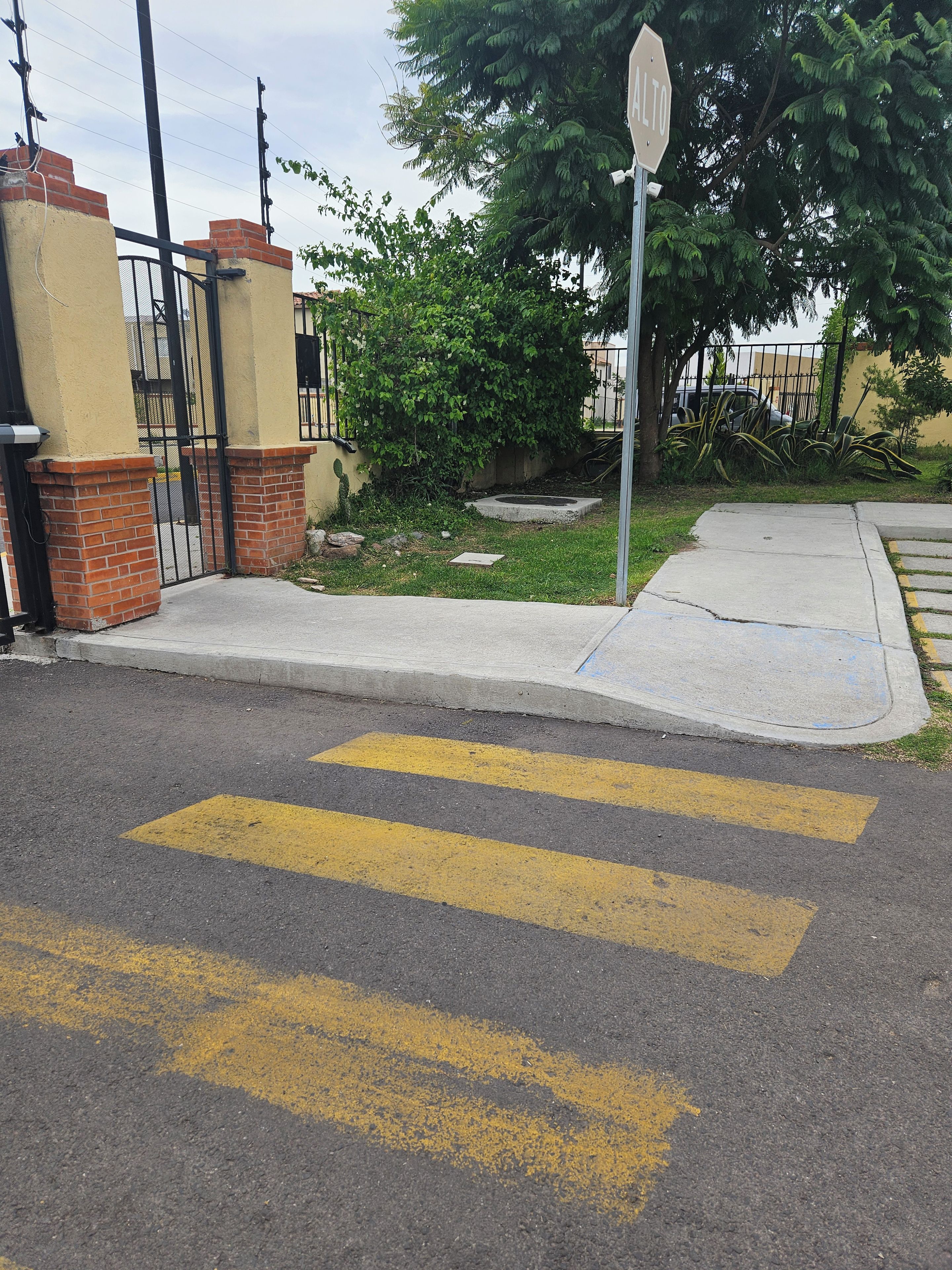 Una intersección de calles con una señal de alto, un paso de peatones y una acera.