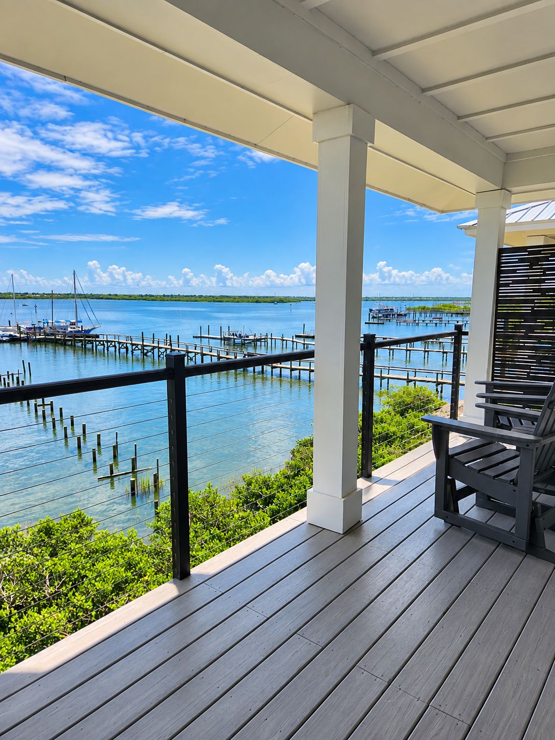 A covered outdoor deck with a view of a marina and water.