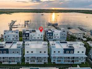 A coastal residential area with modern houses, a dock, and a sunset over the water. - The Grand Mariner: Waterfront + Boat Slip + Elevator Luxury Estate (St. Augustine)