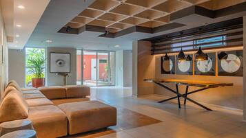 Un interior moderno con un sofá modular, una mesa de comedor y lámparas colgantes.