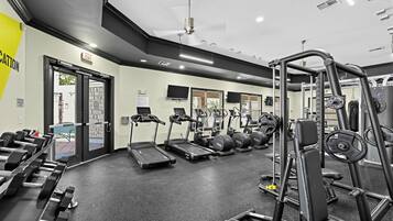 A gym with treadmills, weight machines, and dumbbells.